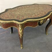 Table avec plateau ovale richement décoré de marqueterie Boulle en laiton doré et écaille de tortue rouge, encadré de bronze