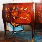 Commode à façade galbée, marqueterie florale, riches bronzes dorés