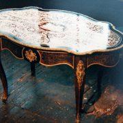 Table ovale laquée noir er décor rouge et or avec ornements en bronzes dorés