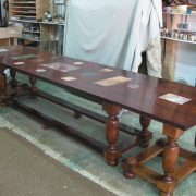 Grande table de salle à manger en bois foncé avec incrustations de marbre sur le plateau