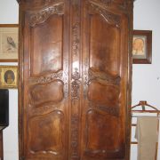 Armoire en bois massif foncé, avec gravures de fleurs et panier